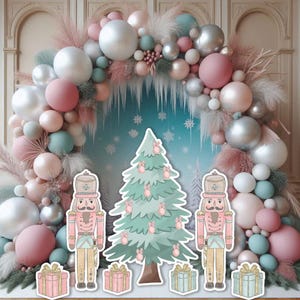 May include: A festive Christmas-themed display featuring a pastel-colored balloon arch, a cutout Christmas tree, nutcracker figures, and wrapped gift boxes. The color palette includes pink, blue, silver, and white, creating a whimsical and celebratory atmosphere.