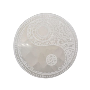 Può includere: Un simbolo Yin Yang rotondo, bianco sporco, con intricati motivi floreali e geometrici bianchi. Il design presenta un bordo dettagliato e un cerchio centrale, creando un pezzo equilibrato e decorativo.