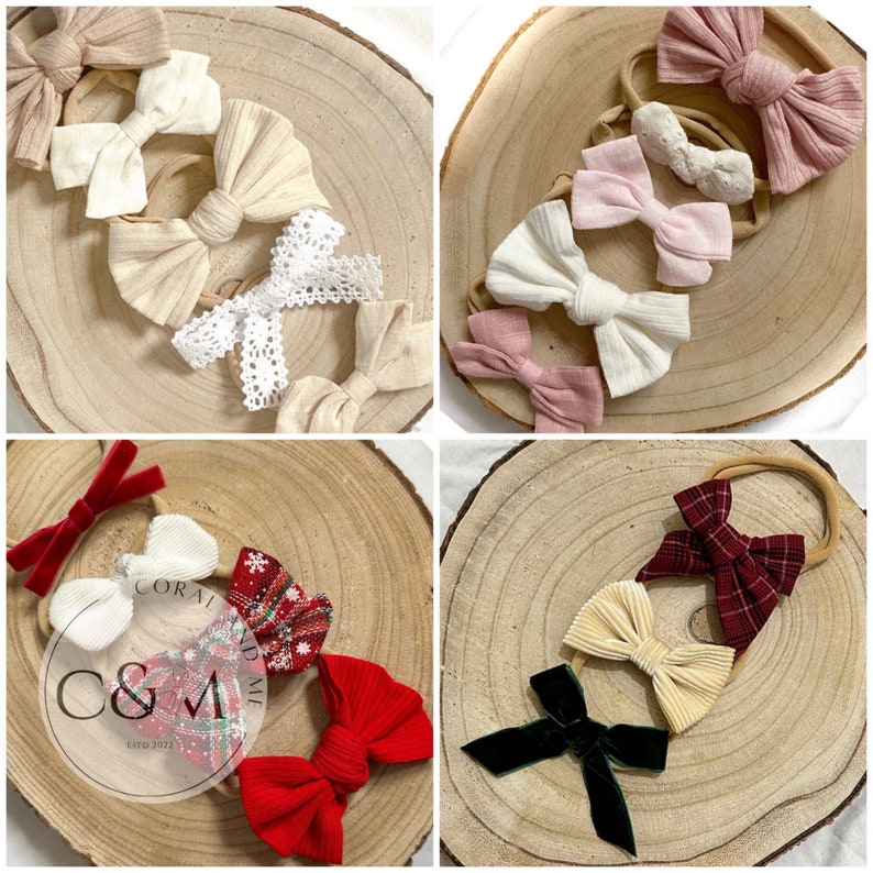 May include: Assortment of handmade hair bows in various colors and patterns, including red, white, green, beige, pink, and burgundy. The bows are displayed on wooden rounds with the text "Coral and Me Est. 2021" visible.