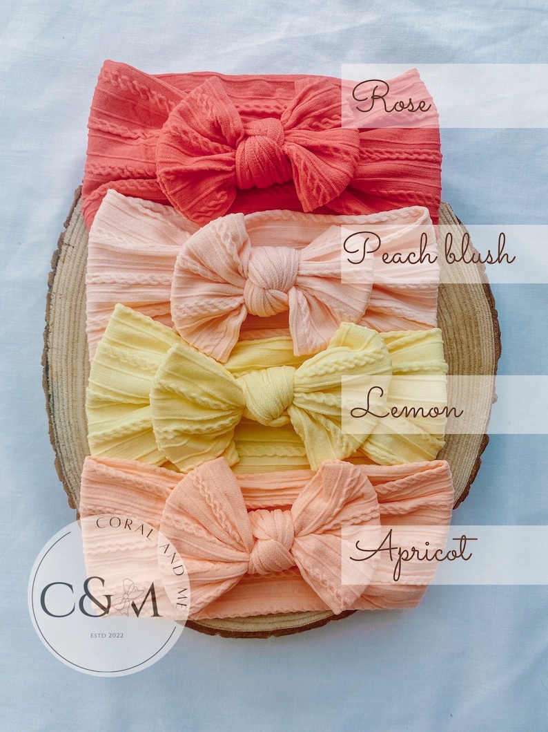 K&ouml;nnte beinhalten: Vier verschiedene Farben von gekn&uuml;pften Stirnb&auml;ndern, von oben nach unten: Rose, Pfirsichbl&uuml;te, Zitrone und Aprikose. Die Stirnb&auml;nder sind auf einer Holzoberfl&auml;che angeordnet. Der Text "Coral and Me" ist in der linken unteren Ecke des Bildes sichtbar.