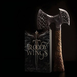 Peut inclure: Une couverture de livre avec le titre "Bloody Wings" en lettres dor&eacute;es sur fond noir. La couverture pr&eacute;sente une &eacute;p&eacute;e avec des ailes d'ange noires et un motif floral fonc&eacute;. Une hache argent&eacute;e avec une poign&eacute;e en cuir tress&eacute; est &agrave; c&ocirc;t&eacute; du livre.