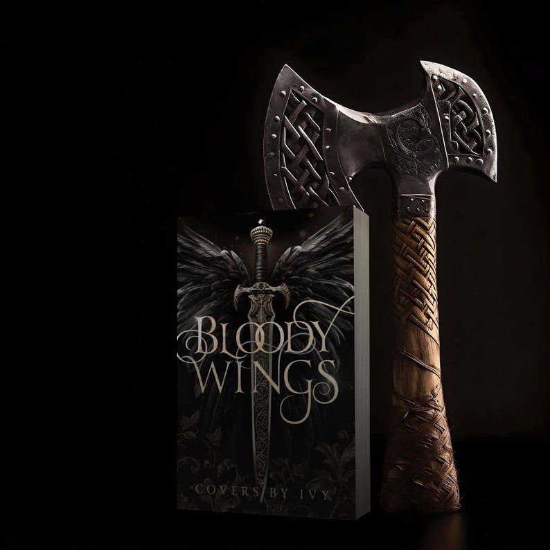 Peut inclure: Une couverture de livre avec le titre "Bloody Wings" en lettres dor&eacute;es sur fond noir. La couverture pr&eacute;sente une &eacute;p&eacute;e avec des ailes d'ange noires et un motif floral fonc&eacute;. Une hache argent&eacute;e avec une poign&eacute;e en cuir tress&eacute; est &agrave; c&ocirc;t&eacute; du livre.