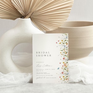 Puede incluir: Una tarjeta blanca con un borde floral y el texto "Bridal Shower" en negro. La tarjeta tambi&eacute;n incluye el texto "En honor a Laura Collins" y la fecha "S&aacute;bado, 11 de junio de 2023".