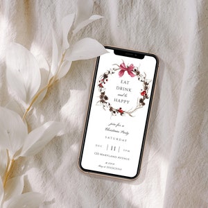 May include: A smartphone displaying a Christmas party invitation with a wreath of cotton bolls, berries, and a pink bow. The text reads "Eat Drink and be Happy", "Join for a Christmas Party", "Saturday", "Dec 11 5pm", "120 Maryland Avenue", and "May at 3225678910".