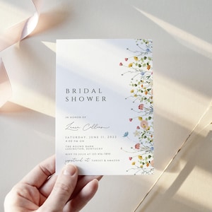 Puede incluir: Una invitaci&oacute;n de ducha nupcial blanca con un borde floral. La invitaci&oacute;n dice "Bridal Shower" en una fuente simple e incluye el nombre "Laura Collins" en cursiva. La fecha es el s&aacute;bado 11 de junio de 2022 a las 2:00 PM. La ubicaci&oacute;n es The Round Barn, Lexington, Kentucky. RSVP al [n&uacute;mero de tel&eacute;fono] antes del [fecha].