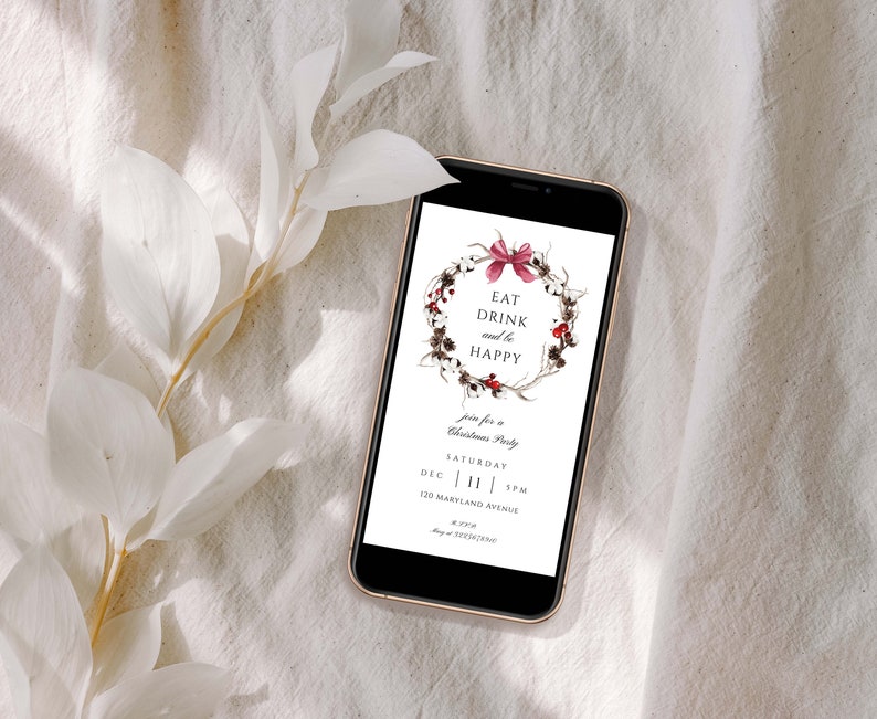 May include: A digital invitation on a smartphone screen with a watercolor wreath of twigs, berries, and cotton. The text reads "Eat Drink and be Happy" and invites guests to a Christmas party on Saturday, December 11th at 3 PM. The address is 120 Maryland Avenue.
