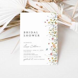 Puede incluir: Una invitaci&oacute;n de ducha nupcial blanca con un borde floral. El texto dice "Bridal Shower" en honor a "Laura Collins" el s&aacute;bado 11 de junio de 2022 a las 4:00 PM en The Round Barn, Lexington, Kentucky. RSVP a Julie al 123-456-7890. Registrado en Target & Amazon.