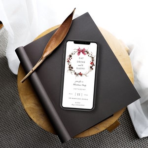 May include: A smartphone displaying a Christmas party invitation with a wreath illustration and the text "Eat Drink and be Happy". The invitation includes the date, time, and address of the party.