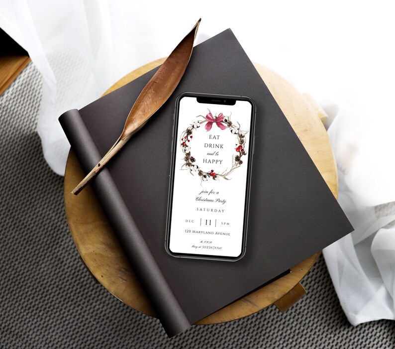 May include: A smartphone displaying a Christmas party invitation with a wreath illustration and the text "Eat Drink and be Happy". The invitation includes the date, time, and address of the party.