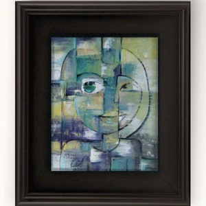 May include: Abstract painting of a face with green eyes and a smile, framed in a black frame.