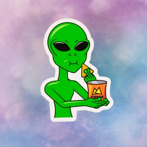 May include: A green alien sticker eating a tortilla chip from a bag of cheese-flavored chips. The alien has large black eyes and is holding the chip with its right hand. The bag of chips has the word "CHEESE" on it.