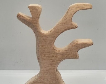 May include: A wooden tree sculpture with a natural finish. The tree has a thick trunk and several branches that extend upwards and outwards.
