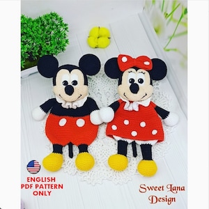 Peut inclure: Des poupées amigurumi au crochet de Mickey Mouse et Minnie Mouse. Mickey porte un short rouge à pois blancs et Minnie porte une robe rouge à pois blancs. Les deux poupées ont des yeux et des nez noirs et sourient.