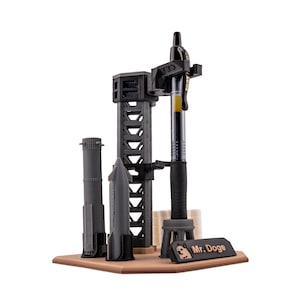 May include: A black and gray desktop organizer shaped like a rocket launchpad with a pen holder, two rocket models, and a sign that reads "Mr. Doge".