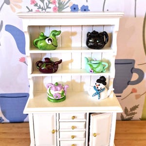 Miniature handcrafted teapots, ready to have a cup of tea in the dollhouse. Choose from six different teapots