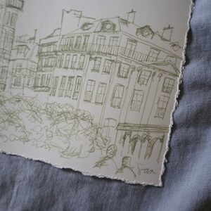 May include: A sketch of a European cityscape with buildings and architectural details. The artwork is rendered in a light green ink on a textured, torn-edge paper. The artist's signature is visible in the lower right corner.