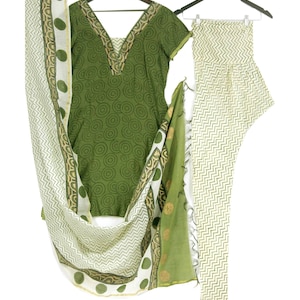 Puede incluir: Un conjunto de ropa de tres piezas en verde y blanco con un patrón estampado. La parte superior tiene cuello en V y mangas cortas. Los pantalones son de pierna recta. La dupatta es una bufanda larga con un patrón estampado.