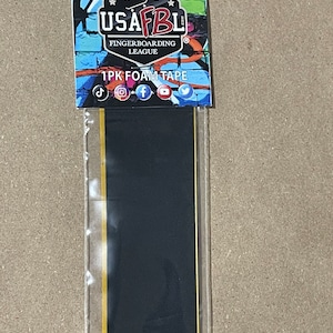 Puede incluir: Un paquete de cinta de espuma negra para fingerboarding. El paquete tiene un gráfico colorido con el texto "USAFBL.com Fingerboarding League 1PK Foam Tape".