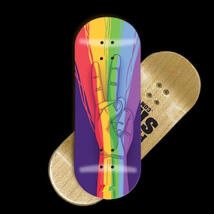 Puede incluir: Fingerboard con un diseño de signo de la paz arcoíris. El fingerboard presenta un fondo púrpura con una mano haciendo un signo de la paz en colores arcoíris. Un fingerboard dorado está detrás. El texto "PLS.COM" es visible.