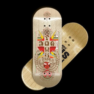 Puede incluir: Dos monopatines de dedo con acabado dorado. Una tabla presenta un gráfico colorido con el texto "A Dog Owns Skates" y un diseño de calavera alada. La otra tabla tiene el texto "S.COM".