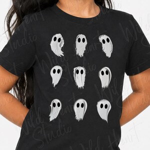 May include: A black short-sleeved t-shirt featuring a graphic print of nine individual white ghosts arranged in a three-by-three grid pattern. Each ghost has a simple, hand-drawn appearance with two dark oval eyes and a rounded, flowing shape.