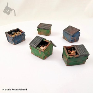 May include: Five miniature resin painted dumpsters, some with lids open, filled with trash. The dumpsters are painted in shades of green, blue, and brown, with rust details. N Scale Resin Painted.