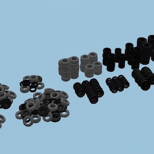 May include: A collection of black and gray rubber rings stacked in various sizes and configurations. The rings are arranged in rows on a light blue background.
