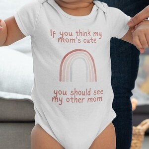 May include: A baby wearing a white onesie with a rainbow and the text "If you think my mom's cute you should see my other mom".
