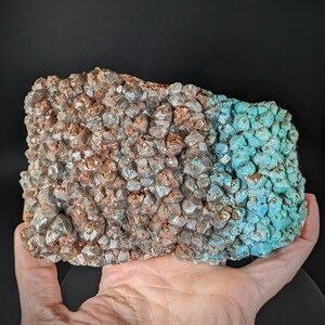 May include: A cluster of quartz crystals with a reddish-brown hue, partially covered by a layer of turquoise blue crystals.