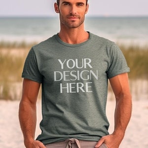 May include: A heather grey t-shirt with short sleeves and a crew neck. The shirt has the text "YOUR DESIGN HERE" printed on the front in white.