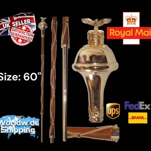 May include: A gold-colored ceremonial staff with a crown and eagle finial. The staff is 60 inches long and has a wooden shaft with a gold-colored braided design. The staff is made of metal and wood.