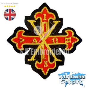 Puede incluir: Parche bordado en forma de cruz, con detalles rojos y dorados sobre fondo negro. El parche incluye el texto "I A Ω" y "S". El diseño es intrincado y detallado, con un borde dorado.