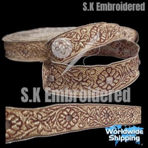 May include: A roll of decorative embroidered trim in gold and burgundy. The trim features a floral pattern and is suitable for various craft and sewing projects. The text "S.K Embroidered" is visible.
