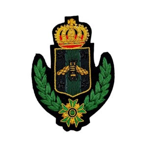 May include: An embroidered patch featuring a bee, a crown and a wreath in green and gold. The bee is at the centre of the patch, surrounded by a green and gold wreath. The crown is on top of the wreath and is gold with red and white accents.