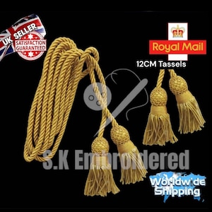 May include: Gold decorative tassels, each 12 cm long, with a woven ball top and a fringe of fine threads. A length of matching gold rope is also included. The image includes the text "S.K Embroidered".