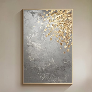 May include: A modern living room featuring a white sofa and a large abstract painting with gold leaf accents. The painting is on a wall with a light grey background. The sofa is positioned in front of a large window with white trim.