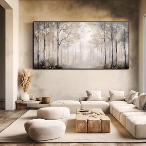 May include: A large, framed canvas painting depicting a misty forest scene in shades of gray and white. The painting features a row of trees with branches reaching towards the sky, creating a sense of depth and tranquility.