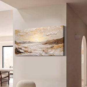May include: A rectangular canvas wall art piece featuring a textured landscape painting. The artwork displays a horizon with mountains and a body of water in shades of white, cream, beige, and brown, created with thick, visible paint strokes.