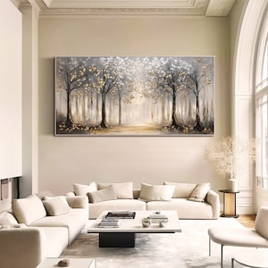 May include: A large rectangular wall art painting featuring a forest scene with dark tree trunks, white foliage, and metallic gold leaf accents. The composition displays a central path leading into a bright, hazy background with a neutral color palette.