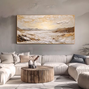 May include: A rectangular landscape painting featuring a textured impasto technique in shades of cream, white, and golden brown. The artwork depicts a coastal scene with rolling waves, rocky shorelines, and distant mountains under a bright sky.