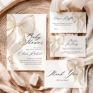 May include: A baby shower invitation set in neutral tones. The main invitation card features a bow illustration and the words "Baby Shower." Other cards include "Diaper Raffle," "Books for Baby," and a thank you card.