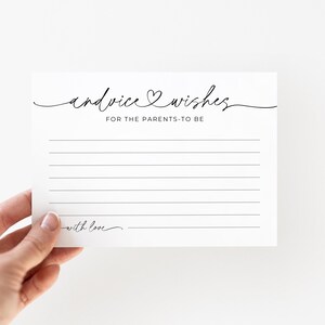 May include: A white card with the text "advice & wishes FOR THE PARENTS-TO-BE" in black script. The card has lined spaces for writing and the words "with love" at the bottom. The card is held by a hand.