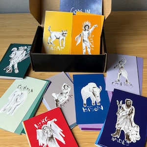 May include: A set of 10 illustrated cards featuring various gods and animals. The cards are printed on different colored backgrounds and feature black and white illustrations. The cards are arranged in a box with the text "Gods in" visible on the top of the box.