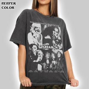 Puede incluir: Una camiseta de manga corta gris carbón con un estampado gráfico blanco de la película Scream. El diseño incluye un collage del reparto, el título de la película y el texto: Someone's taken their love of scary movies one step too far.