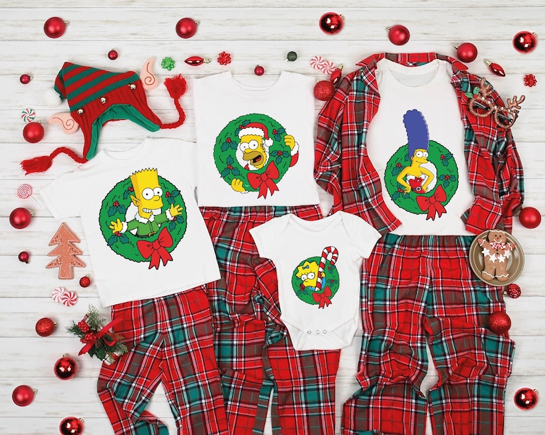 May include: Family matching Christmas pajamas featuring Simpsons characters. Red and green plaid pants and white tops with embroidered wreaths and Simpsons characters like Bart, Lisa, and Santa's Little Helper.  Infant, child, and adult sizes are shown.