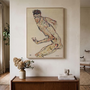 Könnte beinhalten: Ein gerahmter Wandkunstdruck mit einer stilisierten, ausdrucksstarken Figurenzeichnung in gedeckten Beige-, Braun- und Rottönen. Das Kunstwerk zeigt eine verrenkte menschliche Gestalt mit sichtbaren bleistiftartigen Umrissen und Aquarellschattierungen.