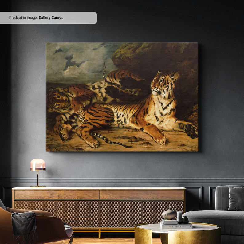 May include: A large rectangular canvas print depicts a painting of tigers. The artwork features several tigers with orange and black stripes, resting on a brown surface. The background includes a cloudy sky and a large rock formation.