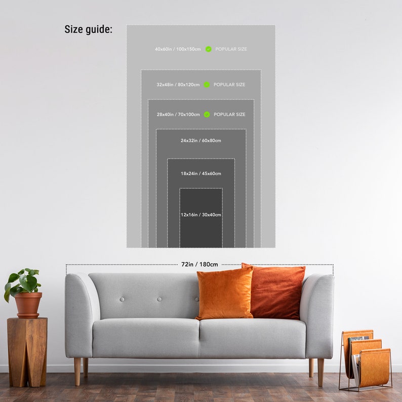 May include: A size guide for wall art prints, showing different sizes in inches and centimetres. The guide is displayed on a white wall with a grey sofa and orange throw cushions in the foreground.