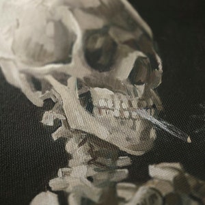 May include: A close-up of a painting depicting a human skull with a cigarette in its mouth. The skull is painted in a realistic style with visible teeth and a detailed jawline. The background is a dark, textured canvas.