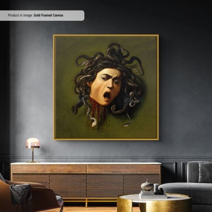 Puede incluir: Un lienzo enmarcado con una impresi&oacute;n de una pintura que representa la cabeza cortada de Medusa, una criatura mitol&oacute;gica griega con serpientes por cabello. La cabeza se representa con una expresi&oacute;n feroz y sangre goteando del cuello. El fondo es de color verde oscuro.
